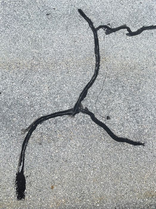 Nahaufnahme mit Teer ausgebesserten Risse in der Strasse, aufgenommen von Thomas Pfister