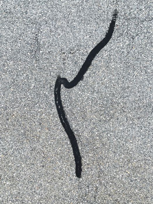 Nahaufnahme mit Teer ausgebesserten Risse in der Strasse, aufgenommen von Thomas Pfister